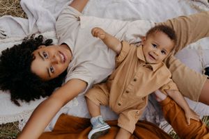 A candid lifestyle photo session showing playful moments on a neutral background.