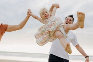 A sequence of candid moments showing family play and laughter at the beach.