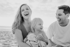 Natural candid moments of family connection captured during a beach photoshoot.