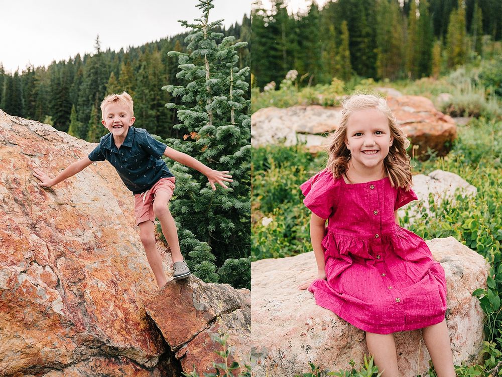 Two children playing on large red rocks surrounded by mountain wilderness and pine trees.