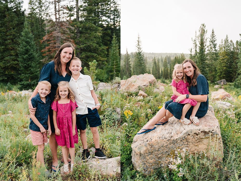 A group portrait in a scenic mountain setting with evergreen trees and large boulders.
