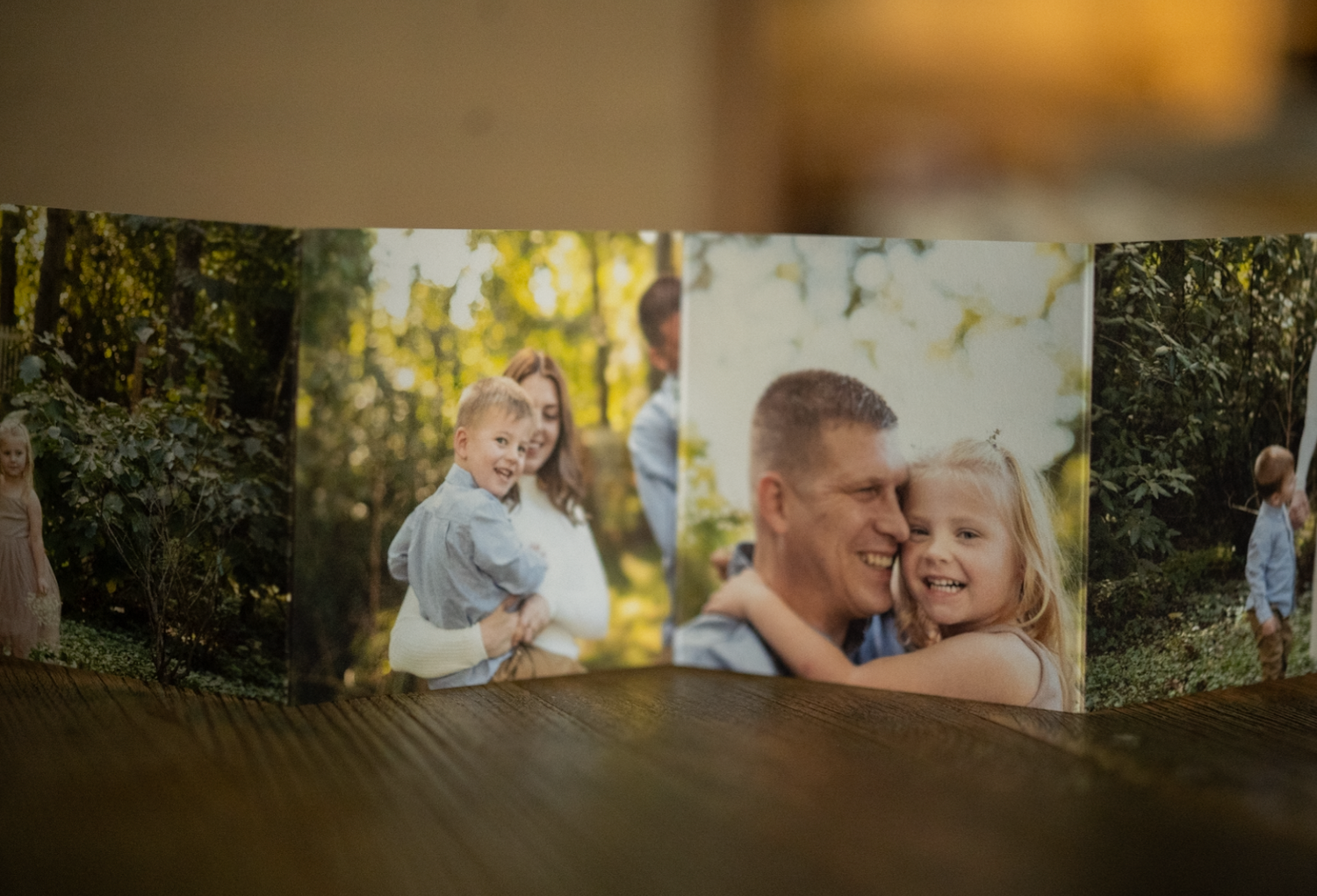 Multiple family photographs arranged in a collage display on a wooden surface.