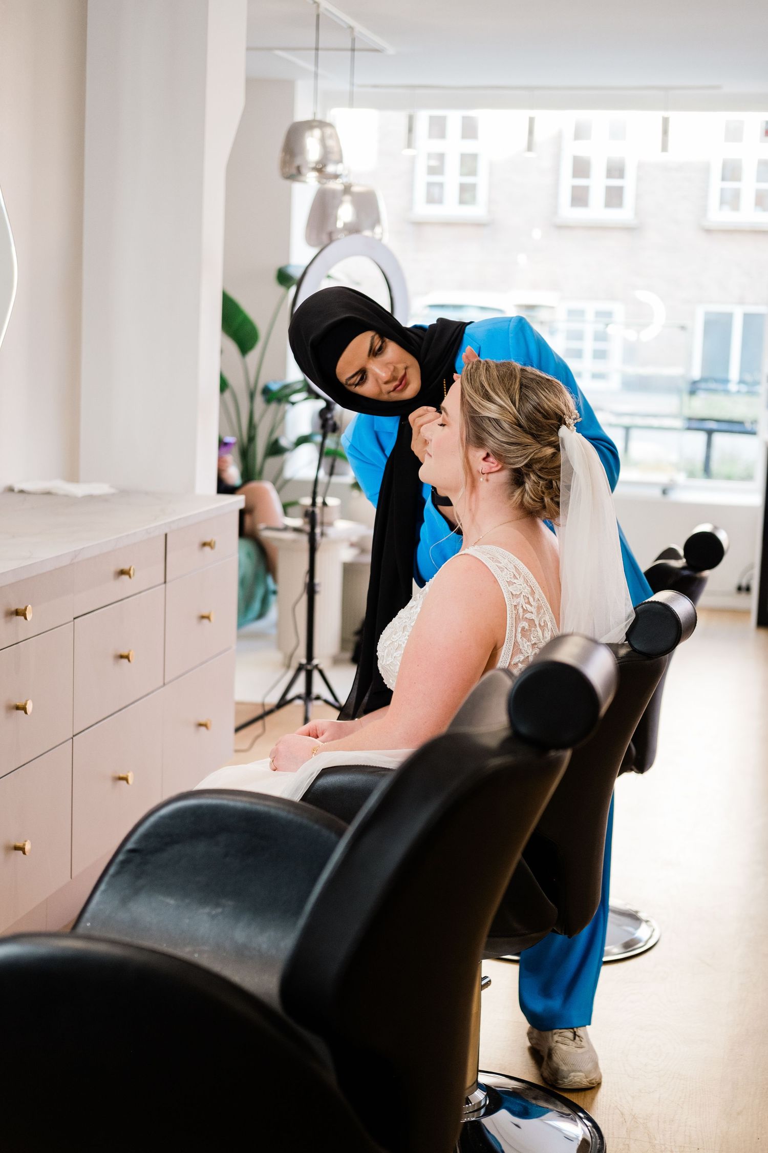 A joyful moment during wedding preparations in a modern, bright salon setting.