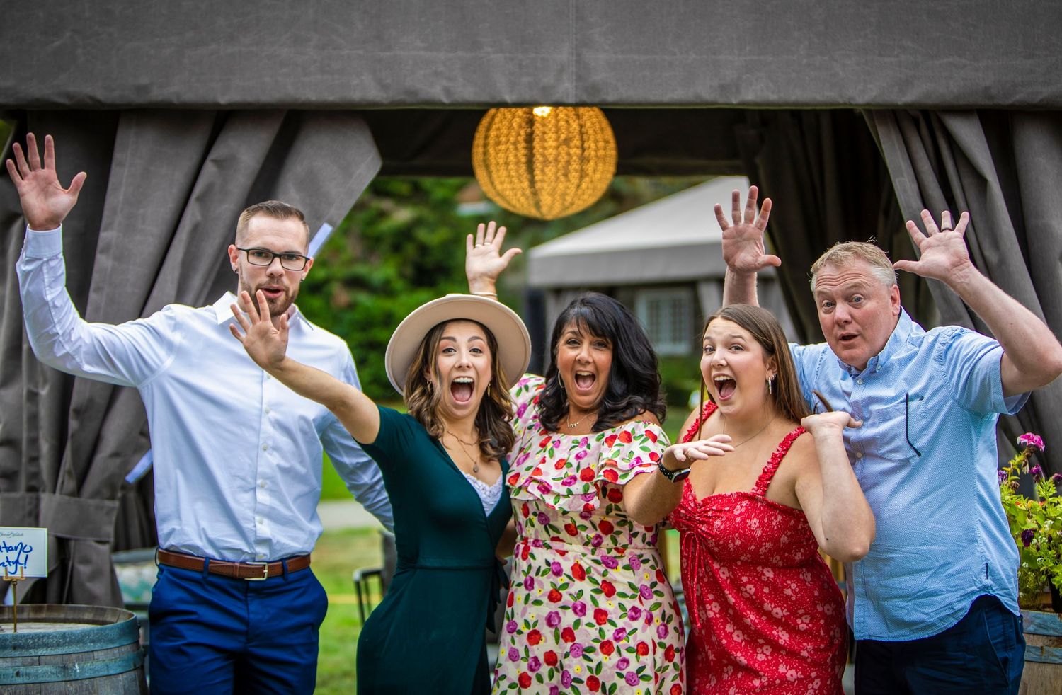 a family with their hand up in the air excited for the wedding proposal
