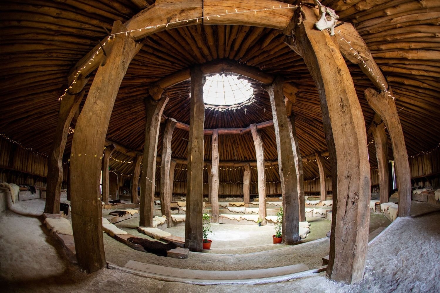 Interior view of a historic circular barn with wooden beams and stone walls.