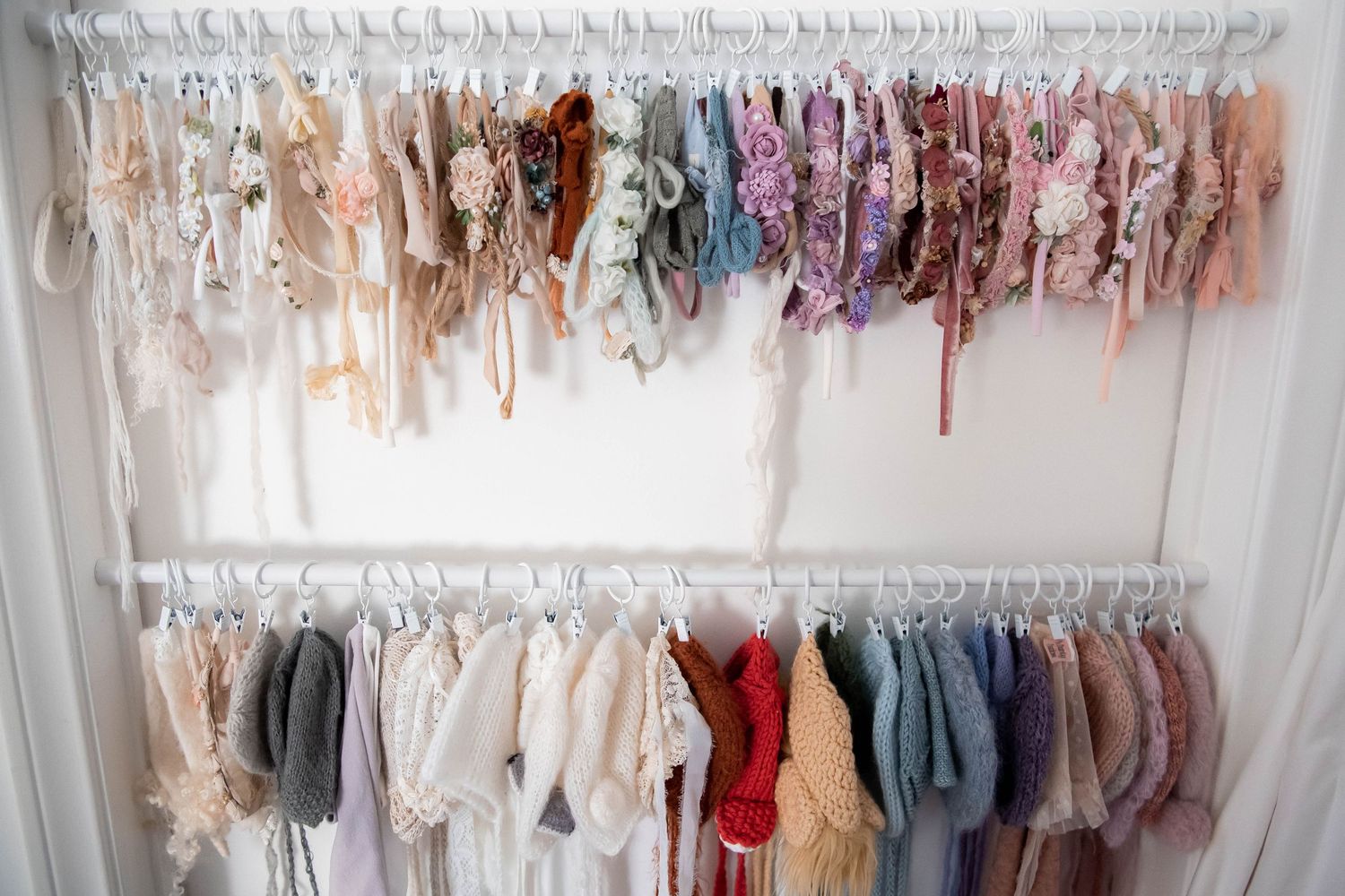 Double rack clothing display with delicate lace and pastel garments hanging in rows.