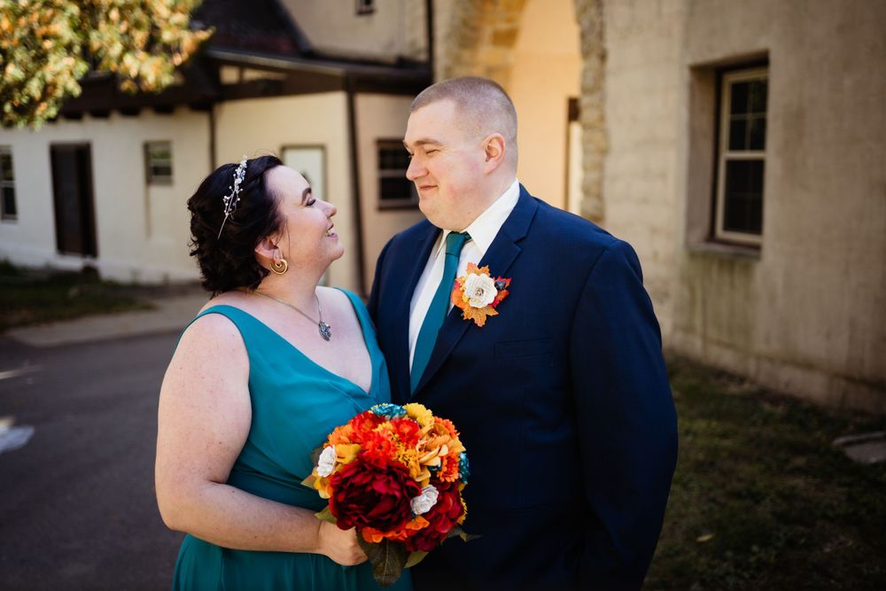A happy wedding moment shared between a couple in teal and navy attire.