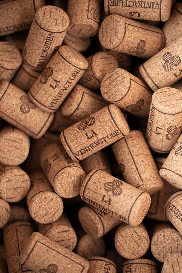 Collection of used wine corks with winery branding viewed from above.