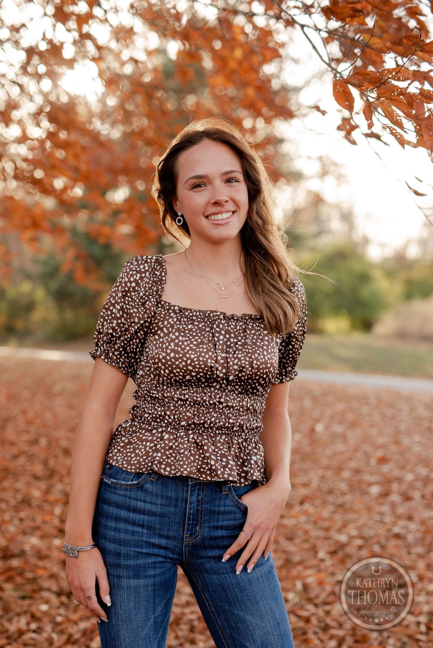 Casual outdoor portrait wearing leopard print puff sleeve top against autumn foliage.