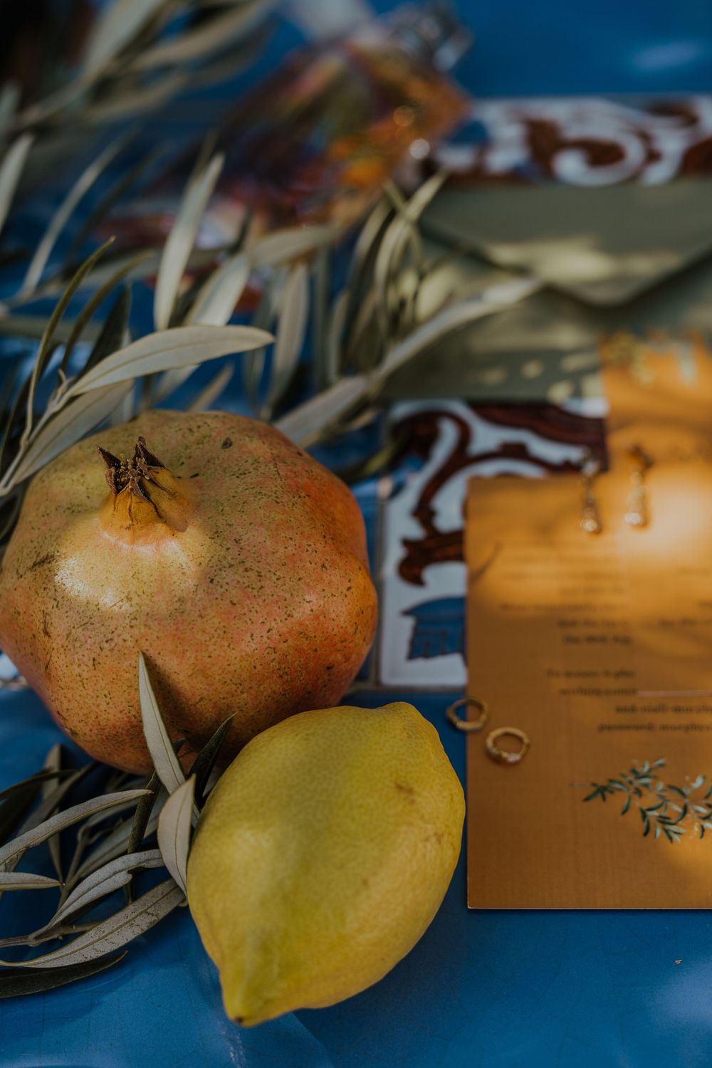 Still life with pomegranate, lemon and orange paper packaging on blue surface. Destination Wedding in Malaga, Spain.