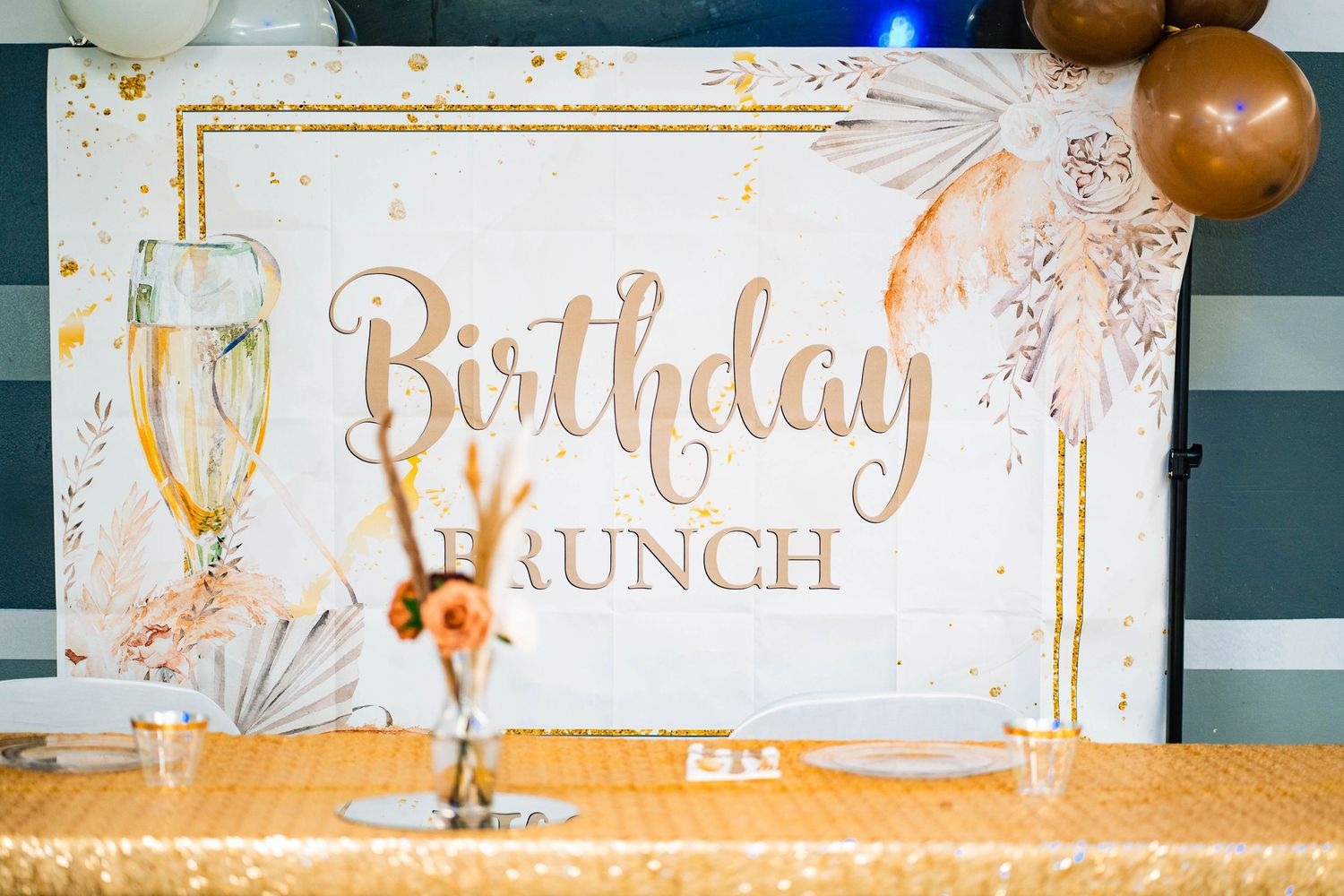 Elegant birthday lunch setup with gold lettering and champagne glass decorations.