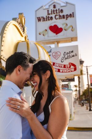 A romantic moment captured outside the Little White Chapel in Las Vegas with its iconic wedding drive-up window sign.