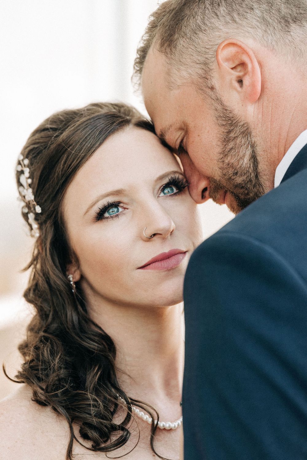 Romantic wedding portrait showing bride's delicate makeup and floral hair accessories.