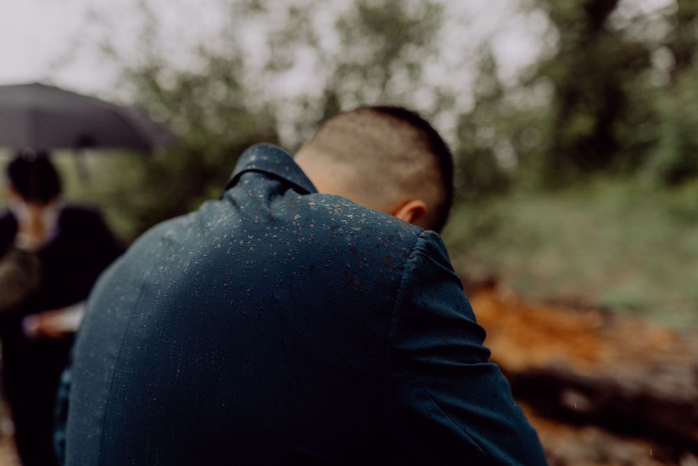 Person in denim jacket sitting outdoors on an overcast day.