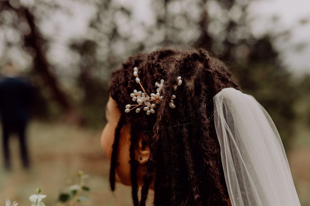 Close-up detail of a bride's hairstyle with delicate floral hair accessories and veil.