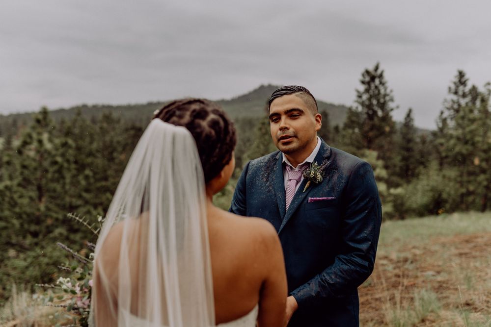Emotional exchange of vows during outdoor mountain wedding ceremony.