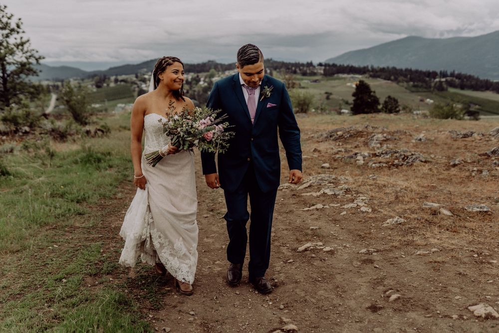 Couple walking together on mountain trail during their wedding day.