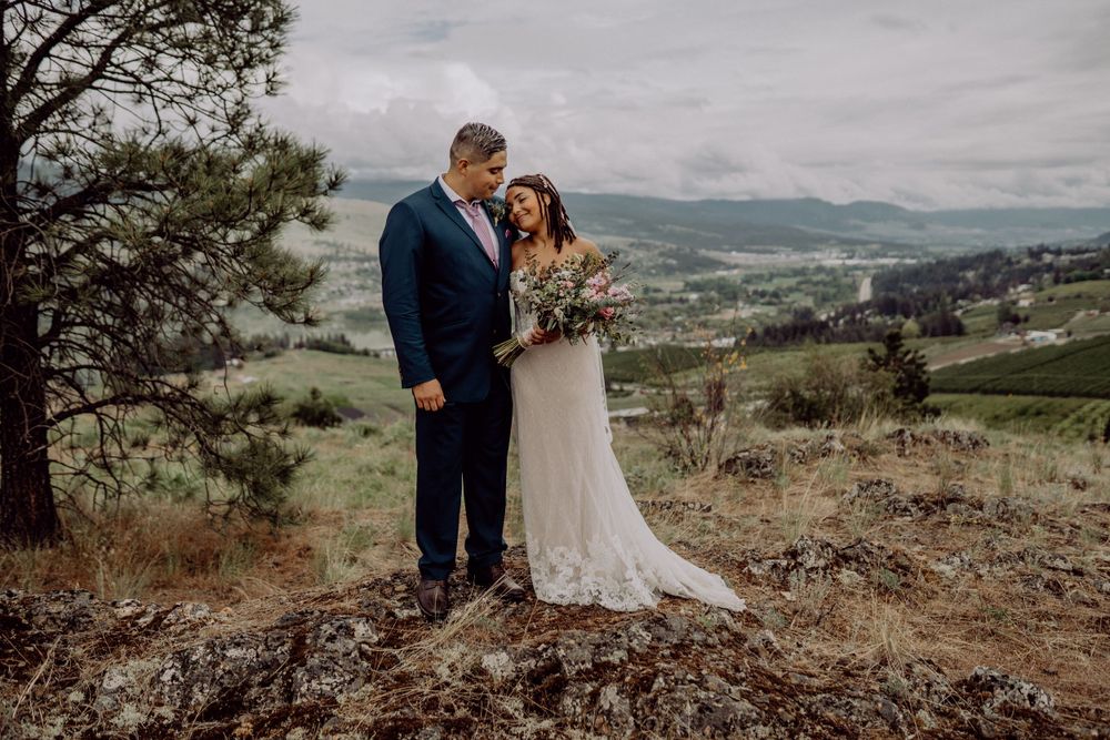 Couple sharing intimate moment on mountain overlook during their wedding.