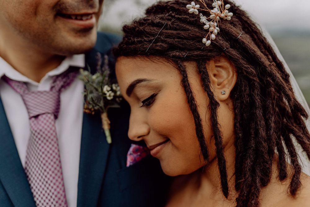 Intimate wedding portrait showing romantic moment with floral hair accessories.