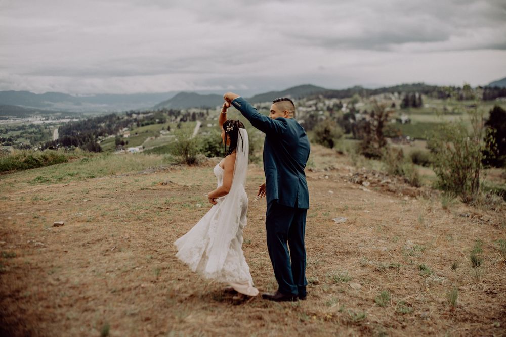 A couple dances together on a scenic mountain overlook during their wedding.