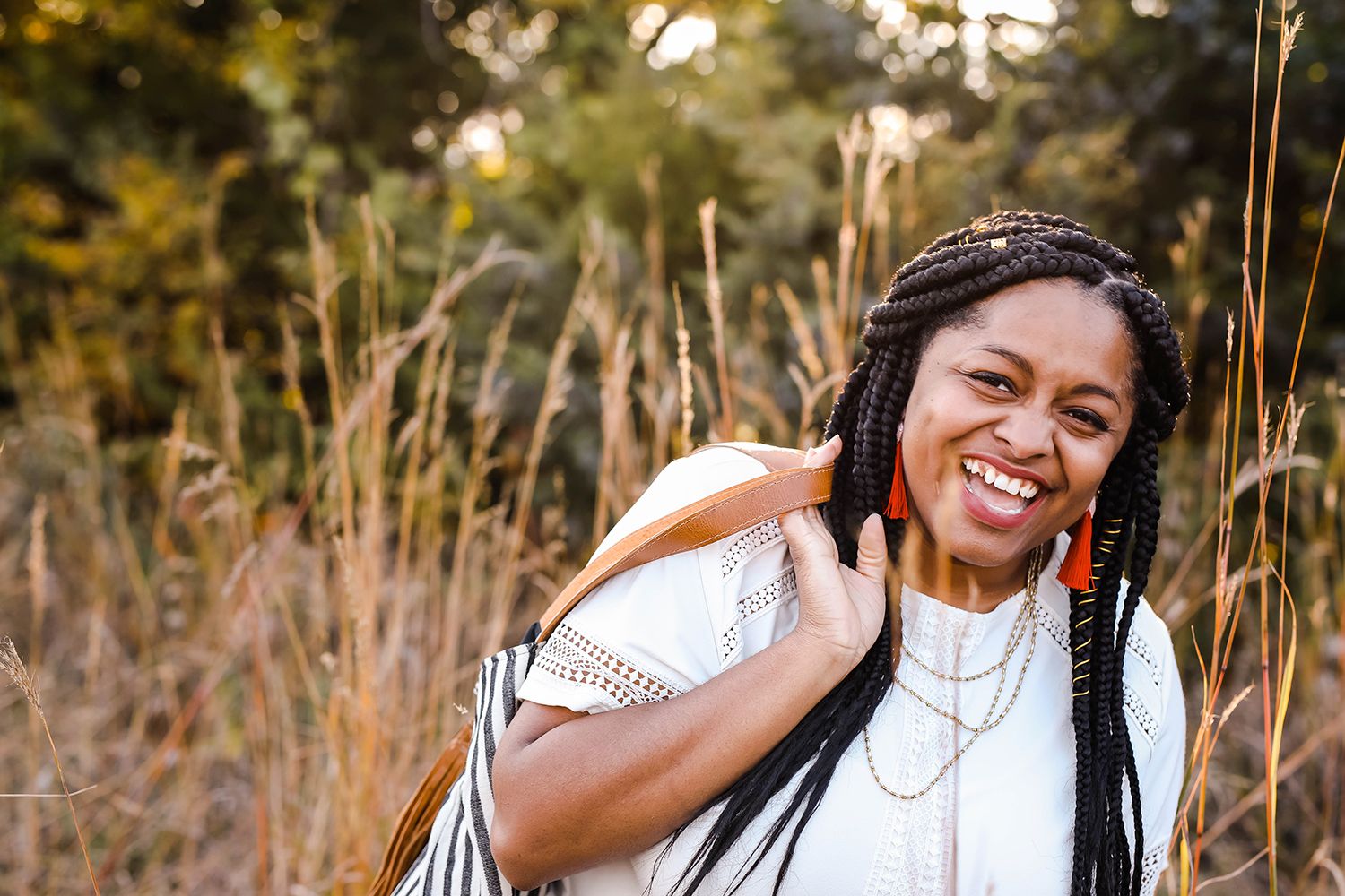 Portrait of a young lady laughing in a field
