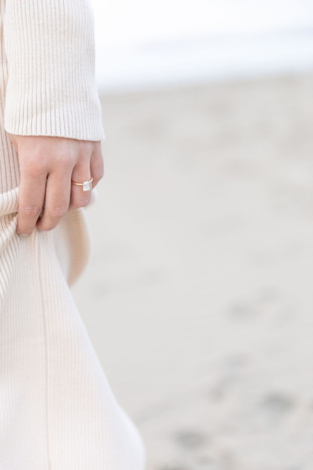 Close-up of a wedding ring on the bride's finger, with a blurred background and a focus on the sparkle and shine.