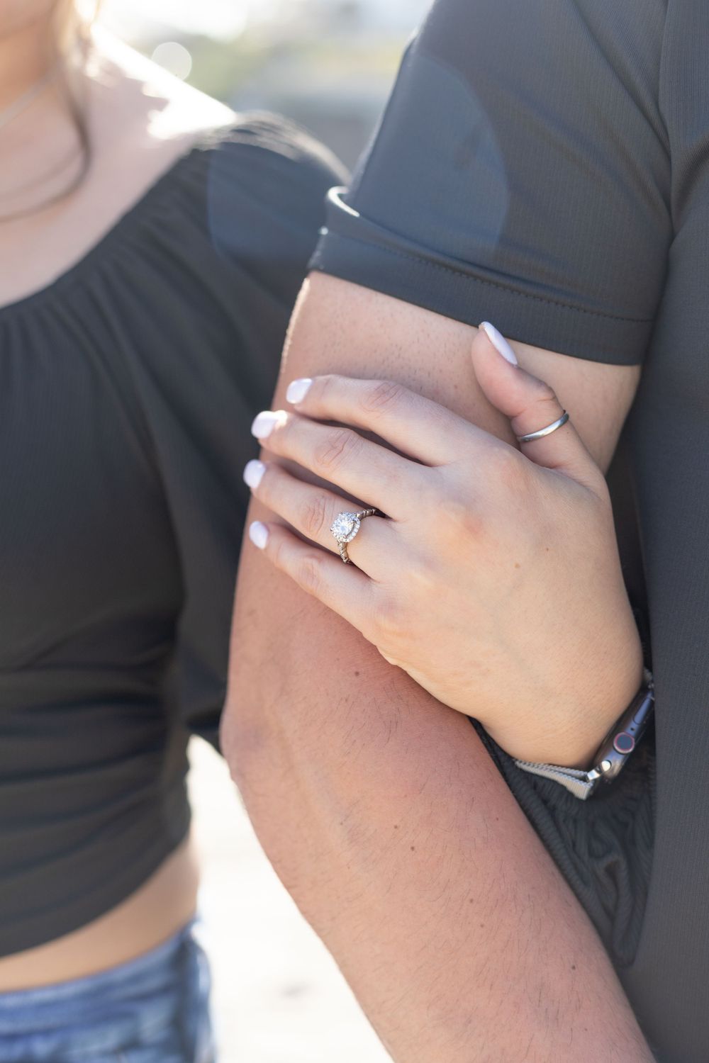 Close-up of a wedding ring on the bride's finger, with a blurred background and a focus on the sparkle and shine.