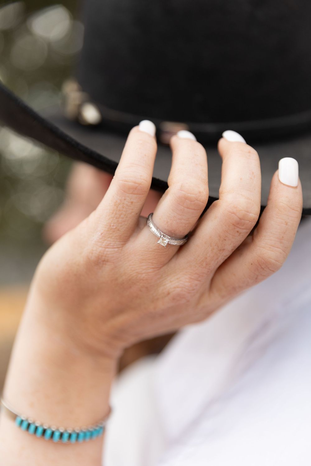 Close-up of a wedding ring on the bride's finger, with a blurred background and a focus on the sparkle and shine.