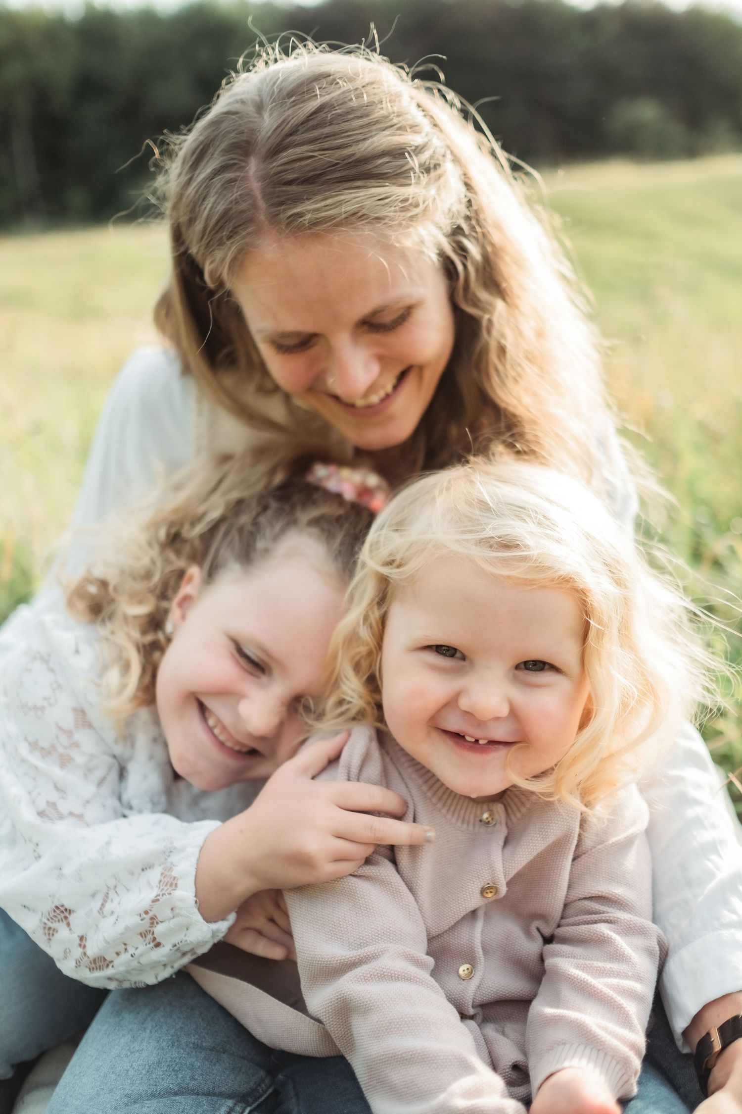 A touching family portrait showing joyful expressions in a sun-drenched field.