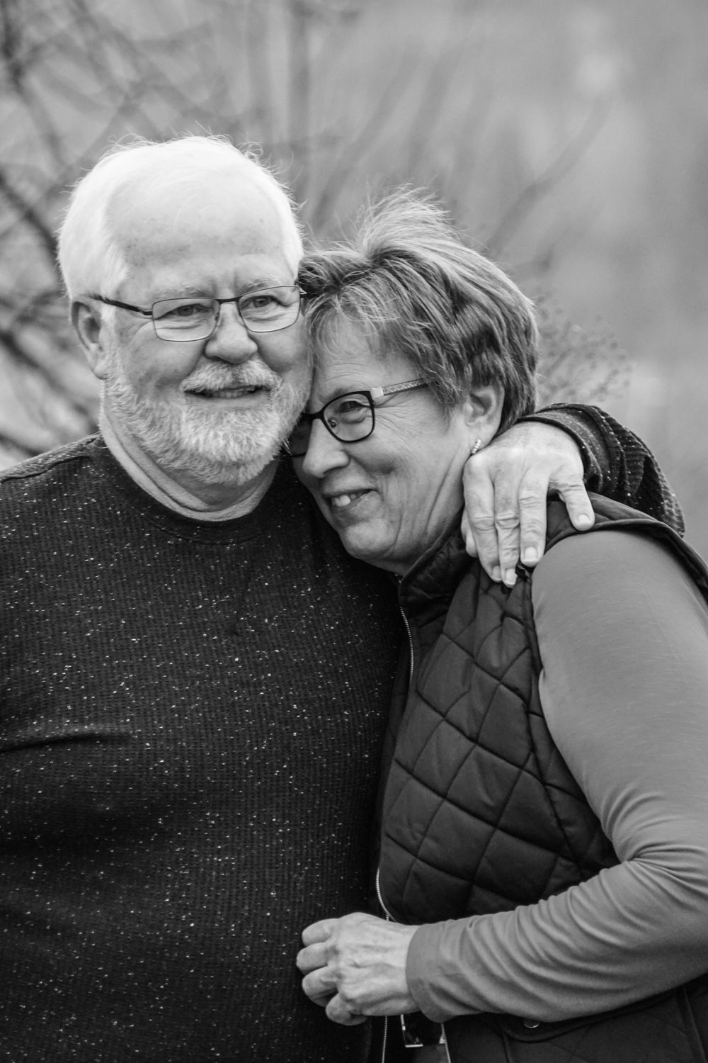 Intimate black and white portrait of senior couple embracing and smiling together.