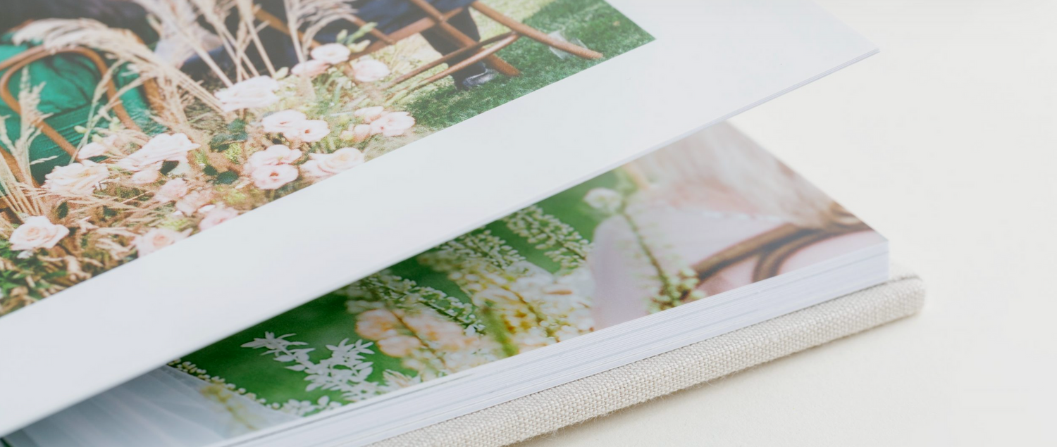 Close-up view of wedding photo album pages with overlapping prints.