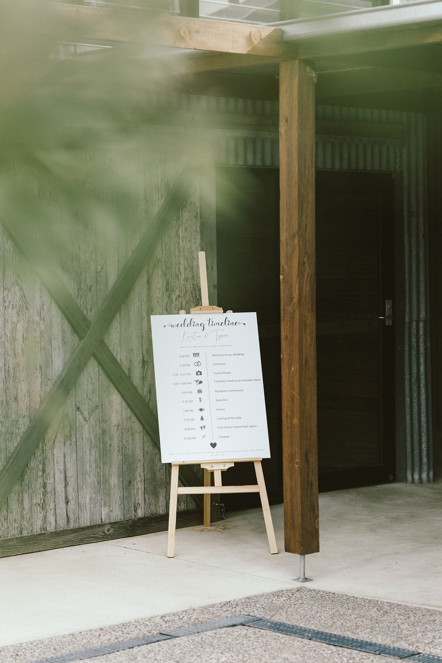 Wedding seating chart display on easels in a rustic wooden venue interior.