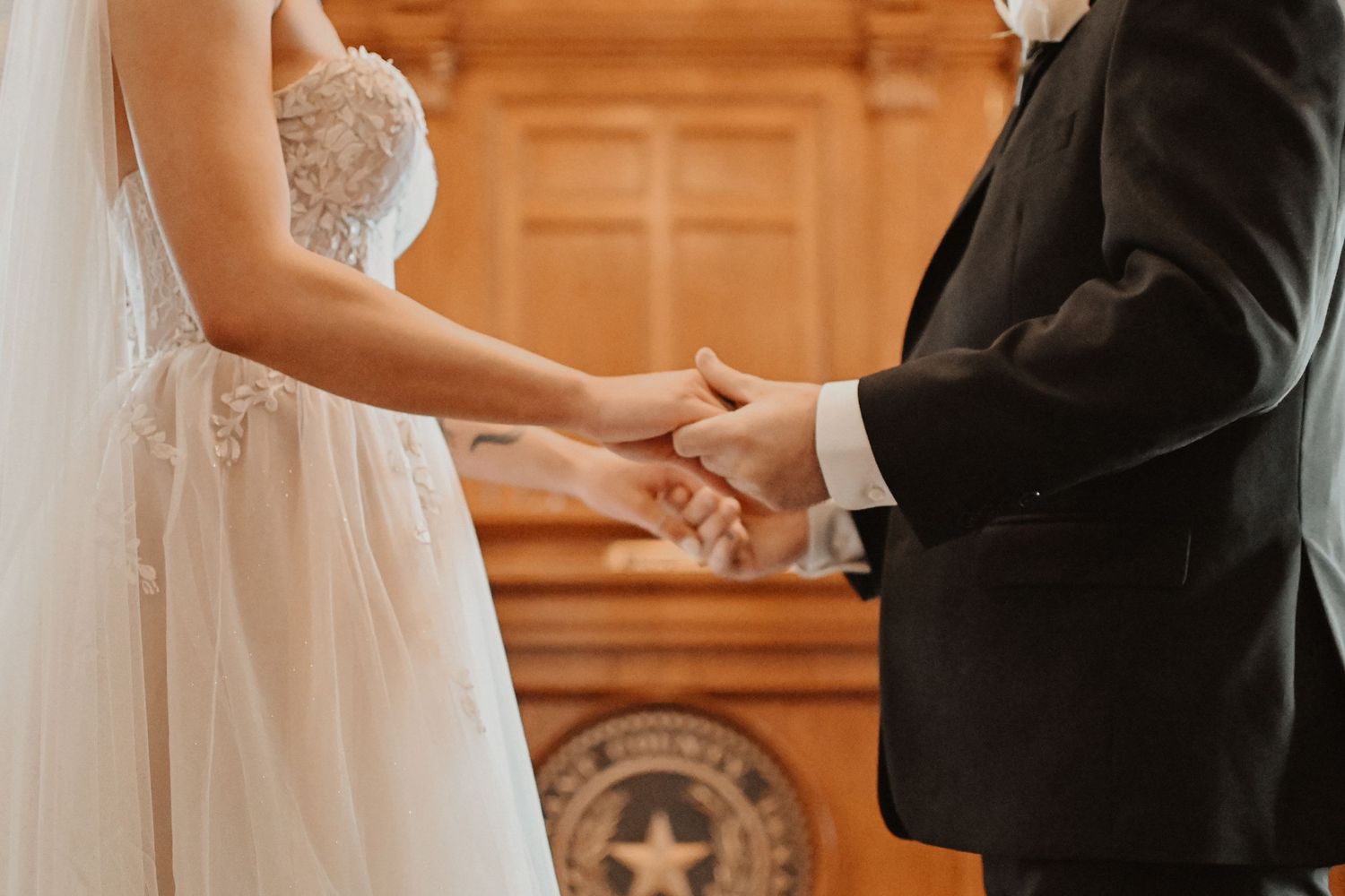 Intimate wedding ceremony moment in a historic courtroom with warm lighting.
