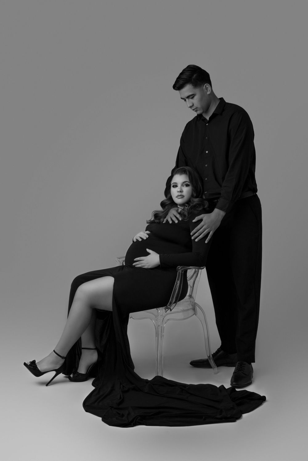 Dramatic black and white studio portrait featuring couple in formal attire.