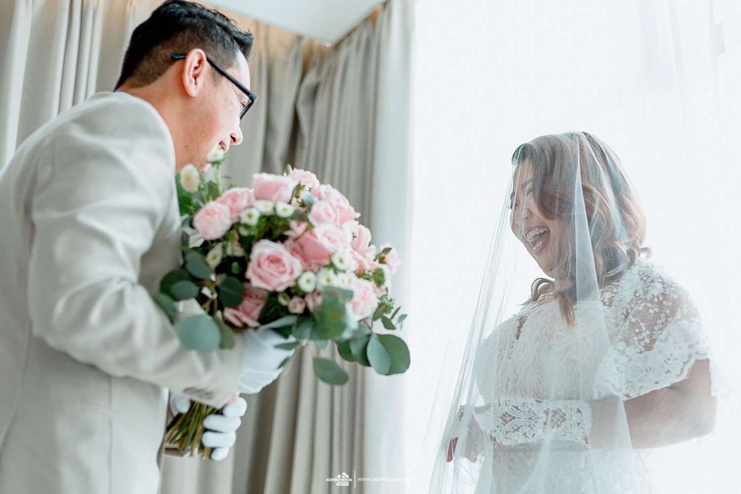 Romantic wedding first look with pink roses and white lace details.