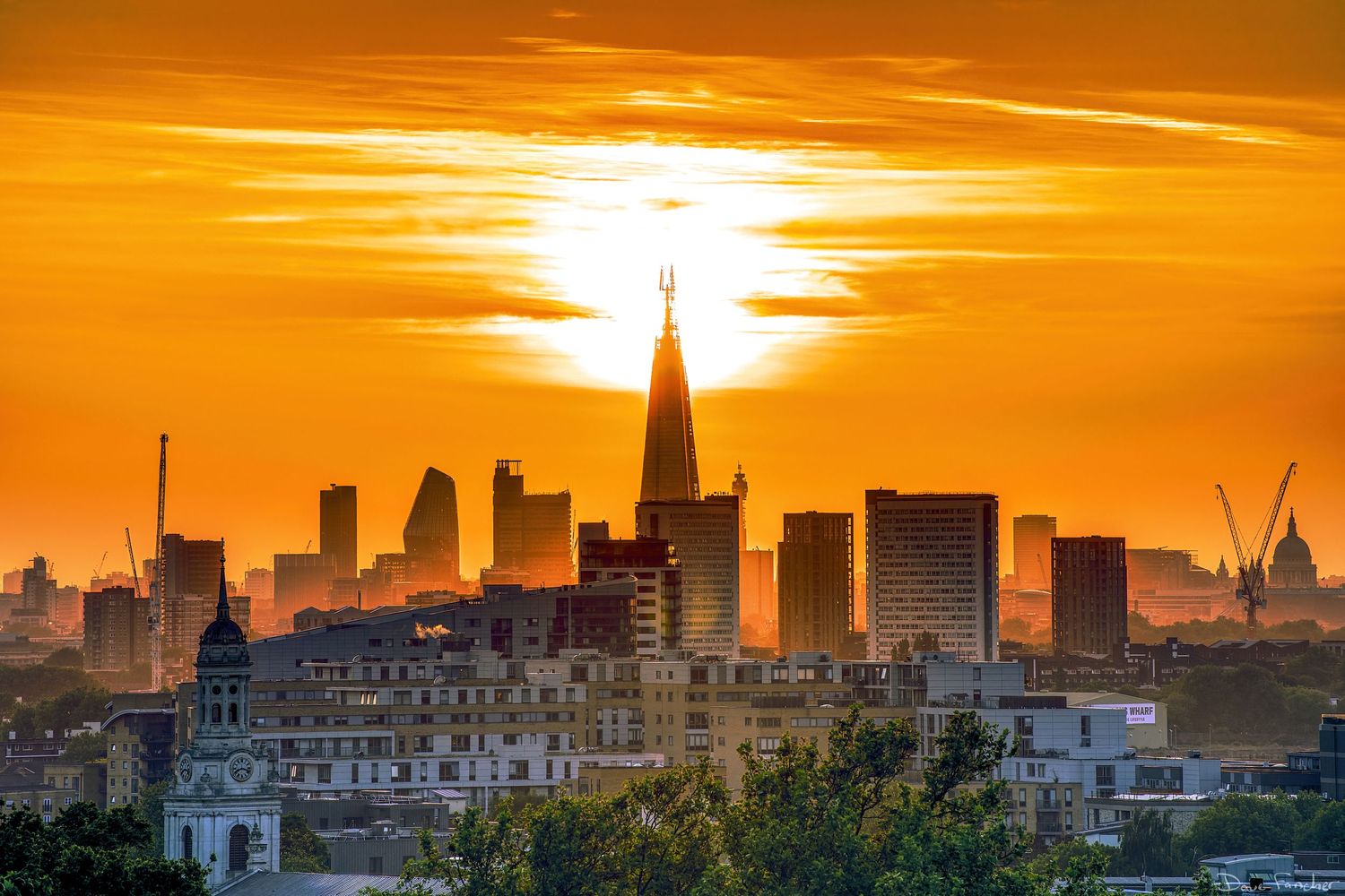 HDR image of the sun setting behind the tip of the Shard in London, England, UK.