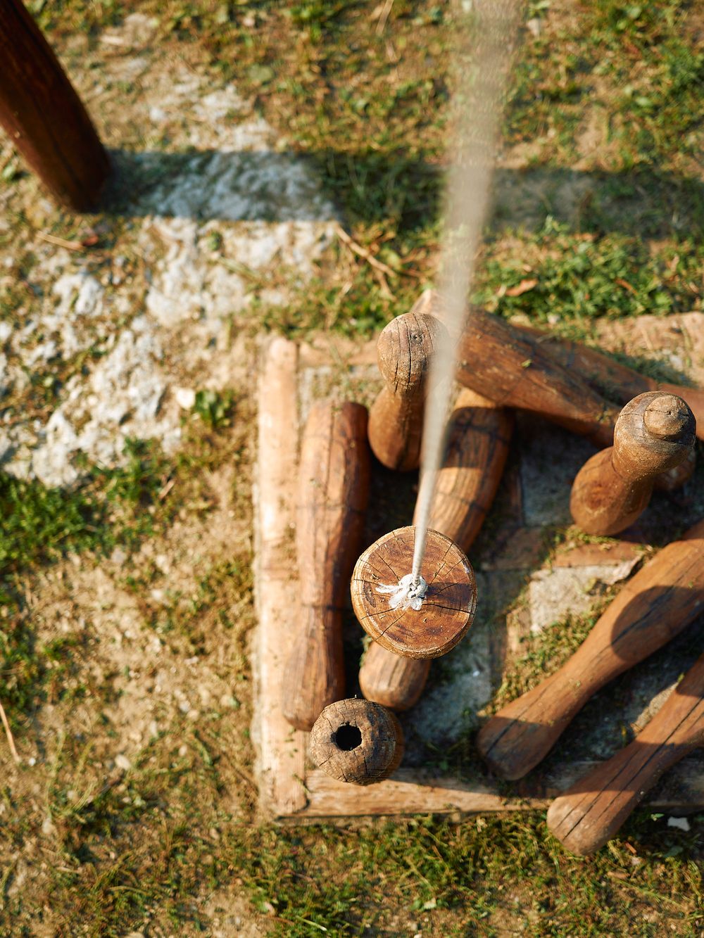 Close-up of water being poured onto hot sauna stones with firewood visible.