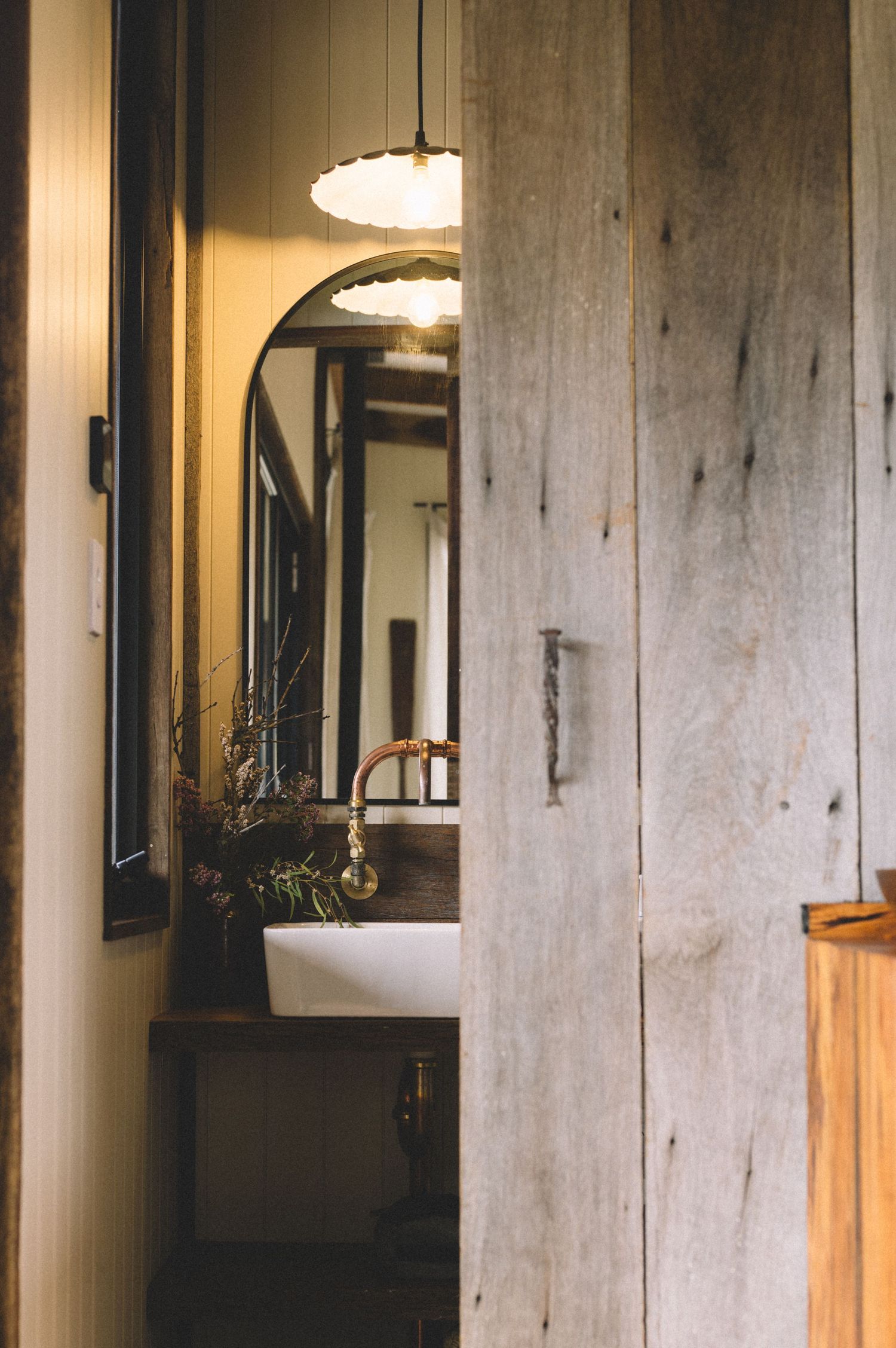 Vintage hallway interior with arched doorway and pendant lighting.