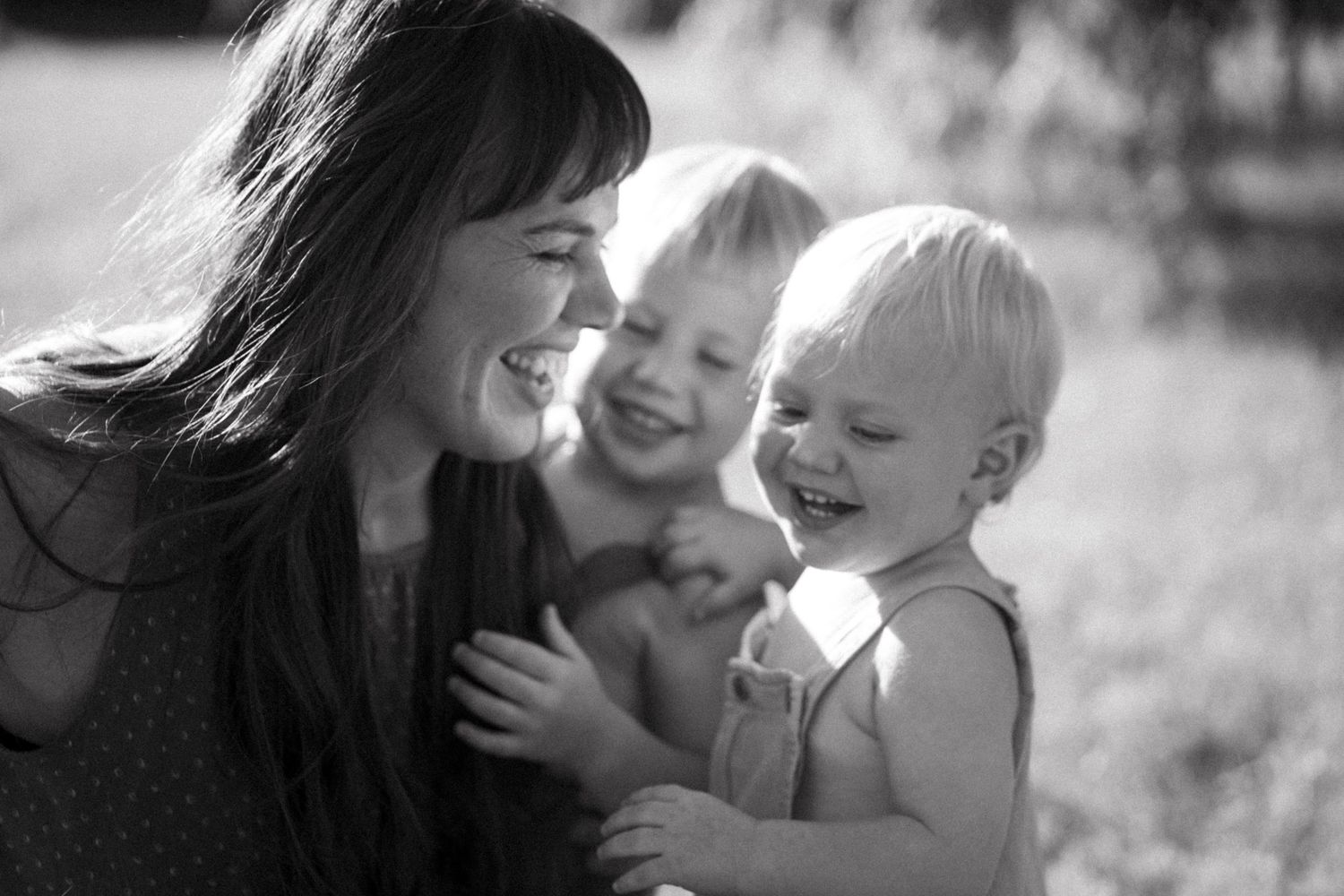Joyful family sharing a candid moment together outdoors in black and white photography.
