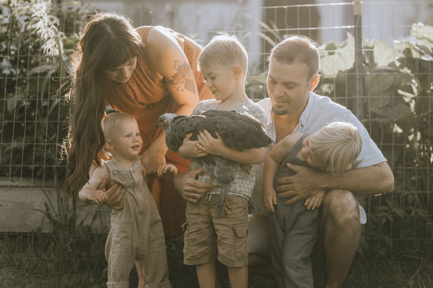 A family shares a tender moment together outdoors in warm evening sunlight.