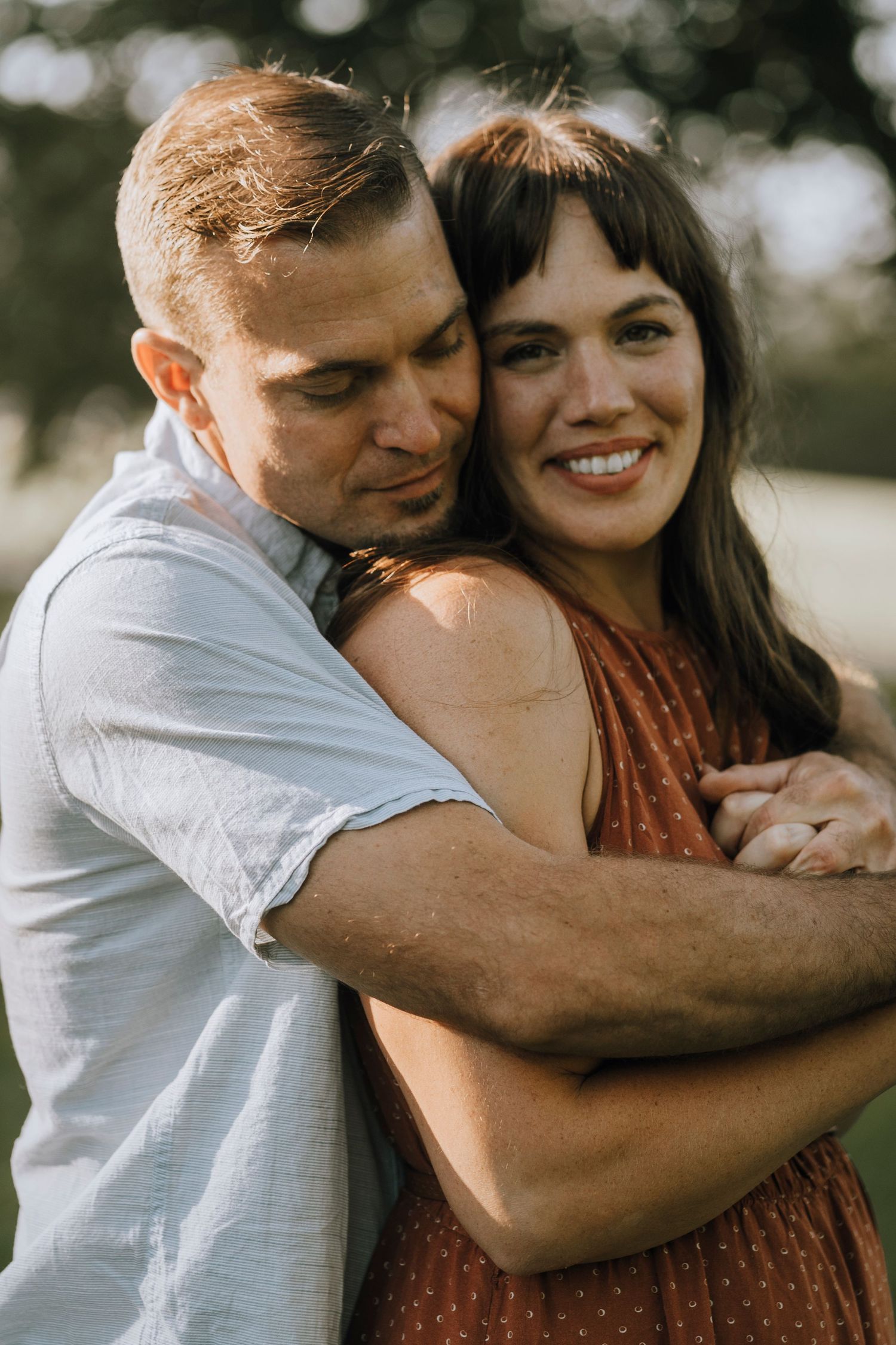 Close-up of couple sharing intimate moment outdoors in natural lighting.