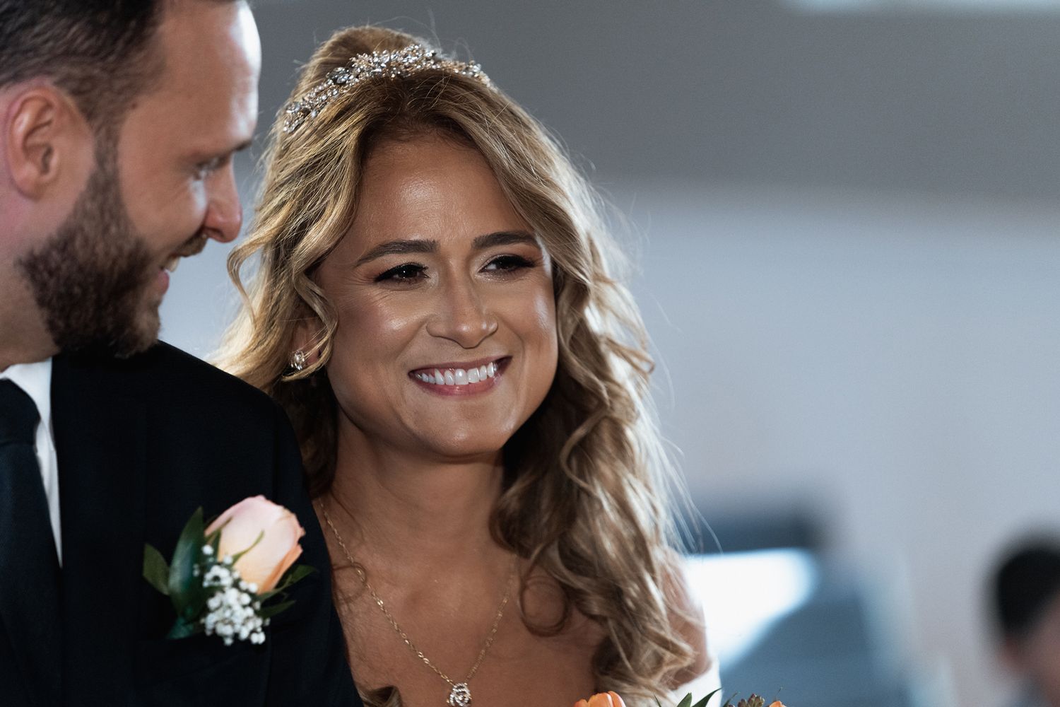 Candid moment during indoor wedding ceremony with natural window light.