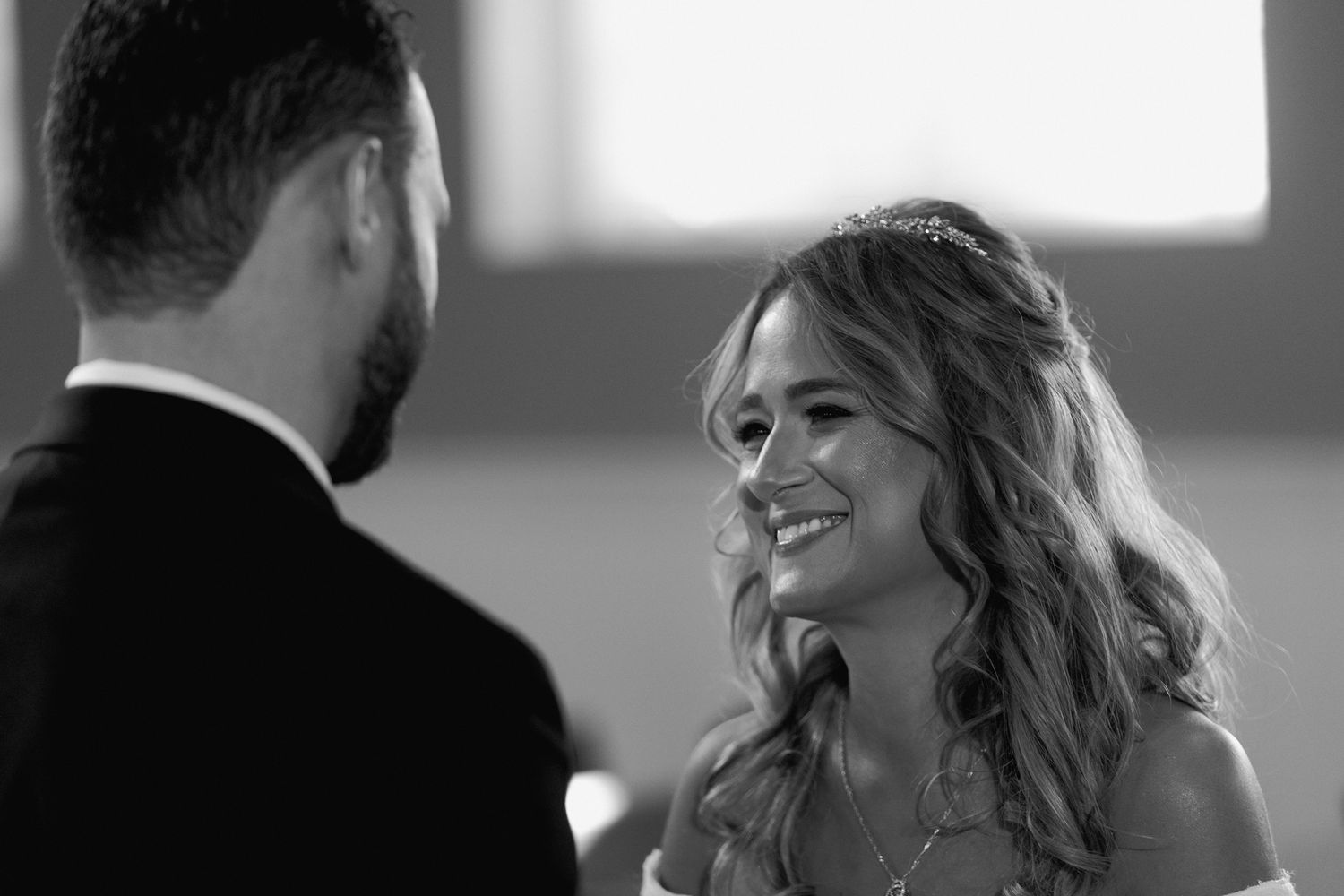 Candid wedding moment captured between couple during ring ceremony.