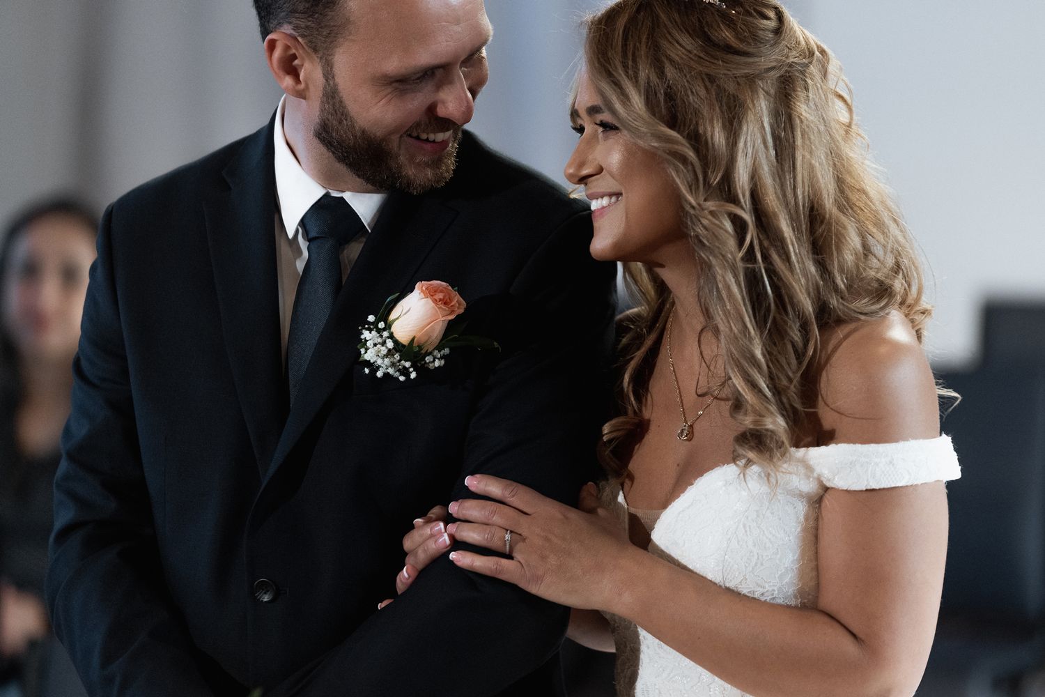 Wedding ceremony close-up showing emotional ring exchange moment.