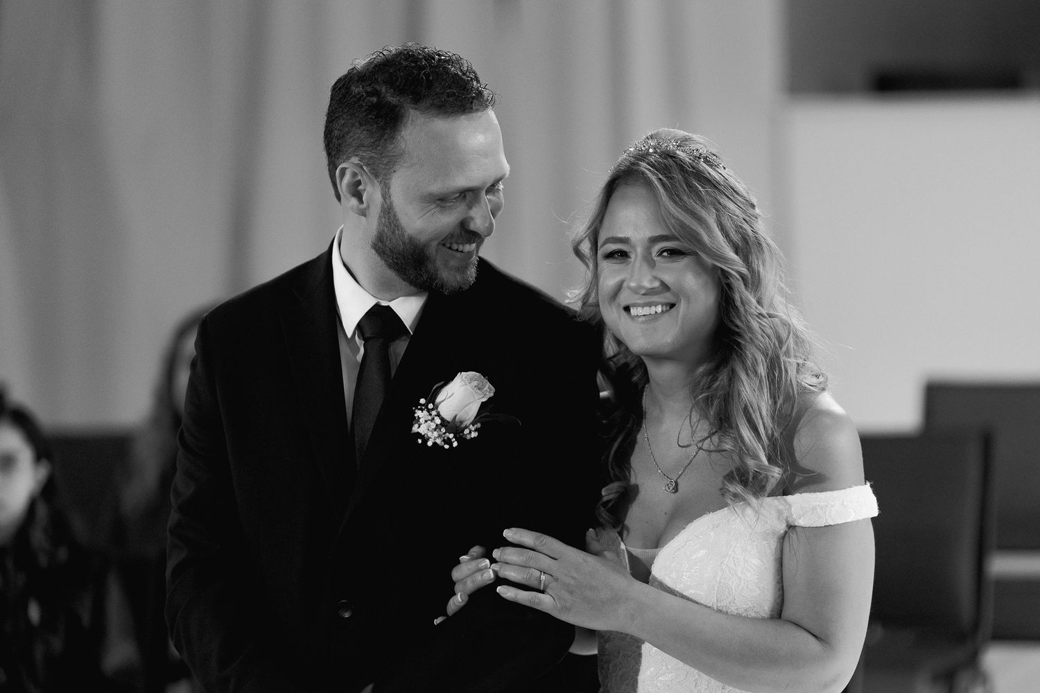 Couple sharing joyful moment during wedding ring ceremony in modern venue.