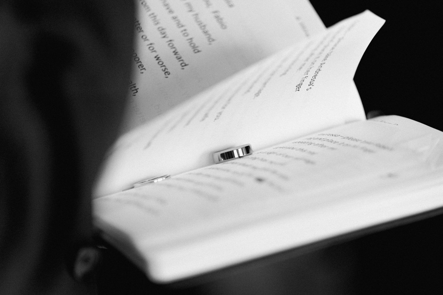 A black and white close-up photograph of an open book with pages turned.