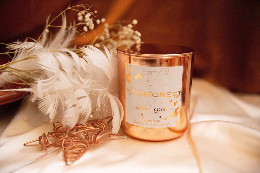 Luxurious candle in a very high-end background with feathers and silk