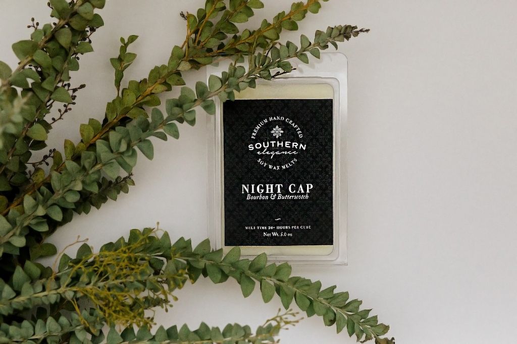 Wax melts decorated with greenery on a white backdrop