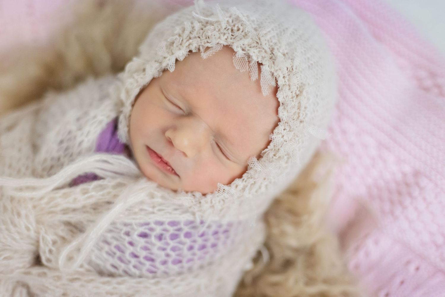 Sweet baby sleeping soundly bounded in an adorable cozy bonnet
