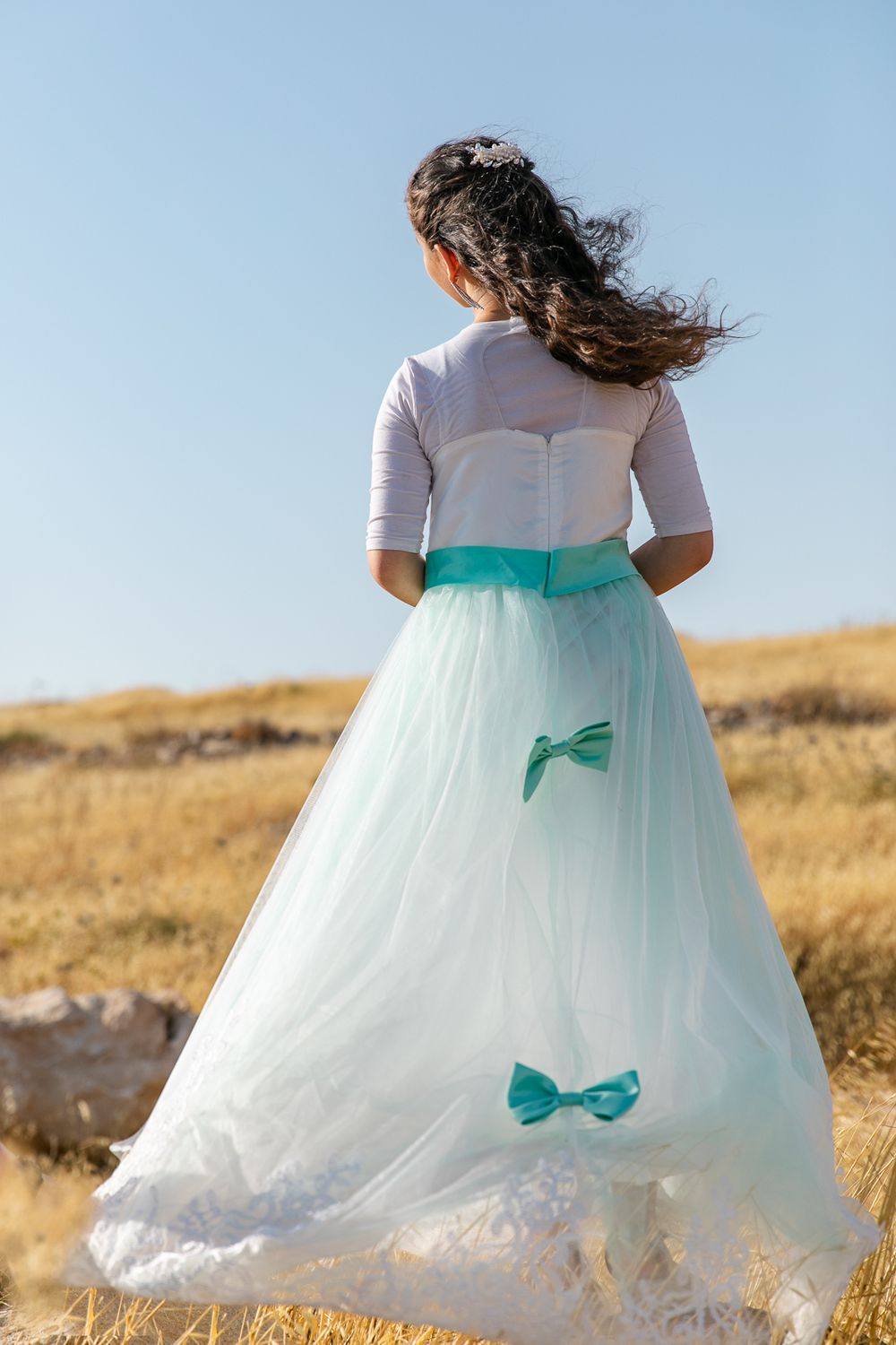a girl standing in the middle of a yellow field